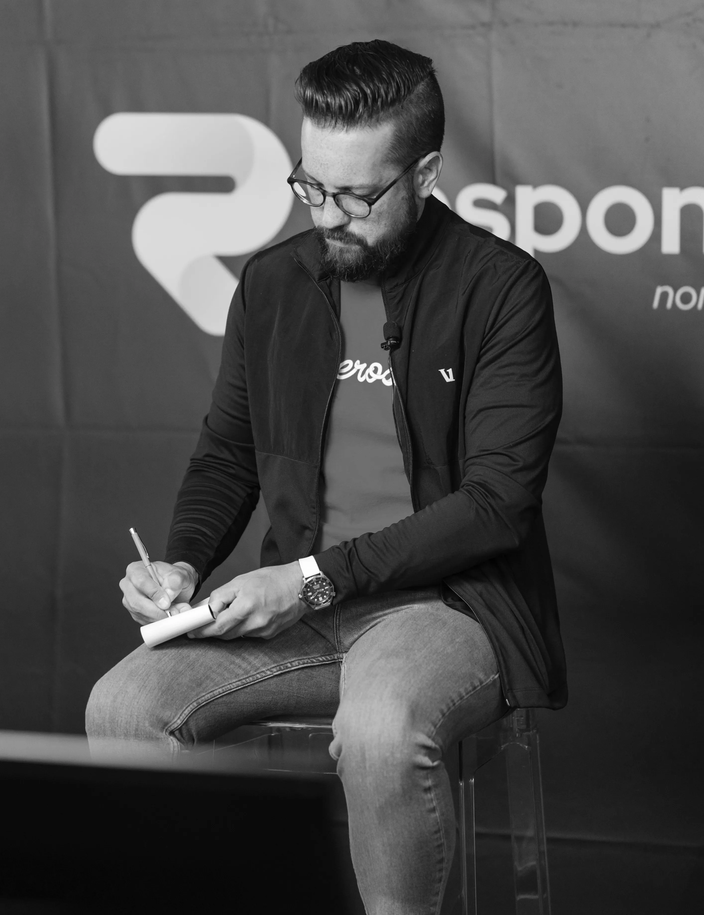 Jason VanLue seated, writing in a notebook